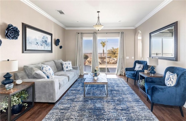 living area with dark wood finished floors, crown molding, arched walkways, and visible vents