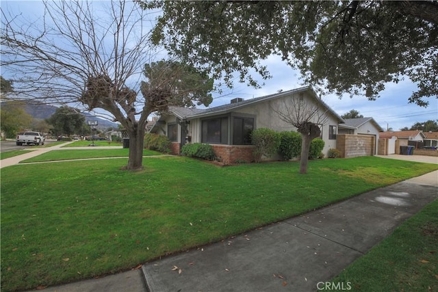 view of side of home featuring brick siding, fence, stucco siding, a lawn, and an attached garage