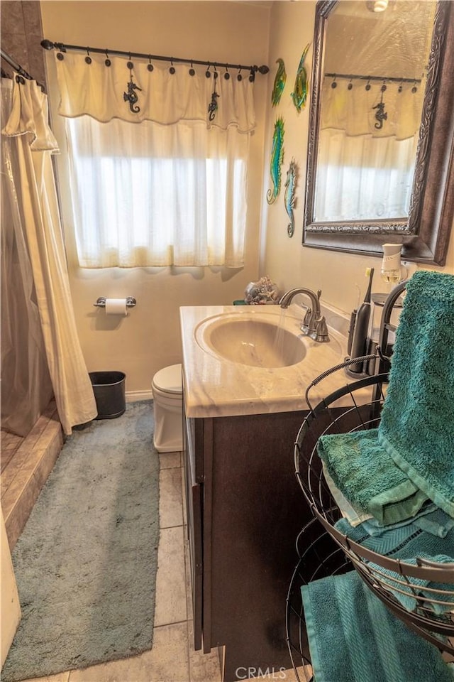 bathroom featuring baseboards, toilet, vanity, and a shower with curtain