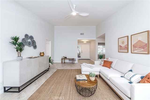 living area with visible vents, baseboards, and ceiling fan