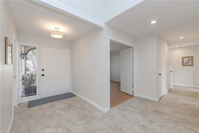 foyer with recessed lighting and baseboards