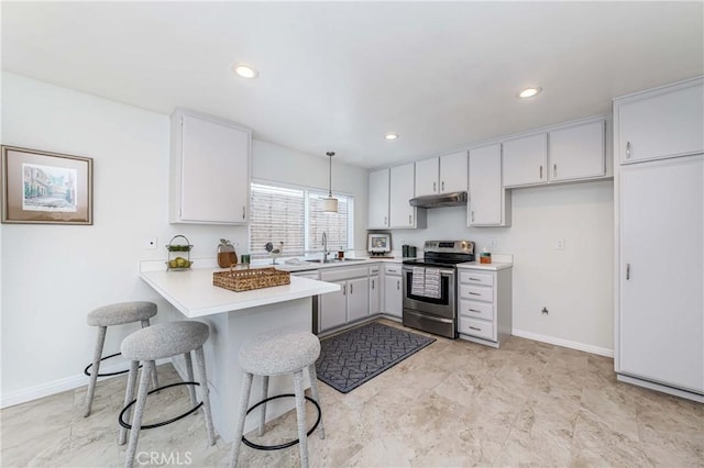 kitchen with baseboards, a peninsula, light countertops, stainless steel range with electric stovetop, and under cabinet range hood