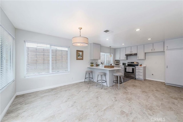 kitchen with visible vents, a peninsula, stainless steel electric range, light countertops, and under cabinet range hood