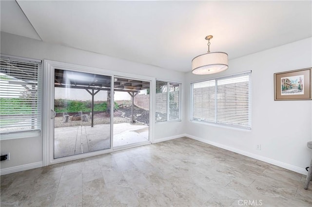 empty room featuring baseboards and plenty of natural light