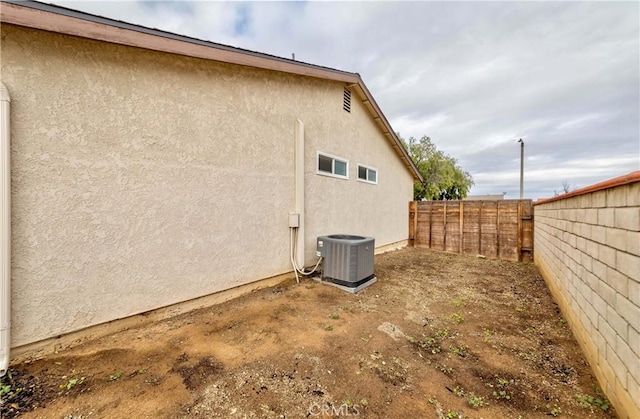 view of property exterior featuring cooling unit, a fenced backyard, and stucco siding