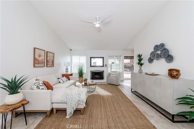 living area featuring a fireplace, high vaulted ceiling, and a ceiling fan