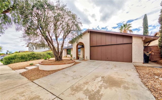 view of front of property with a garage, concrete driveway, and stucco siding