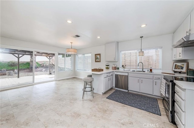 kitchen with visible vents, extractor fan, light countertops, hanging light fixtures, and stainless steel appliances