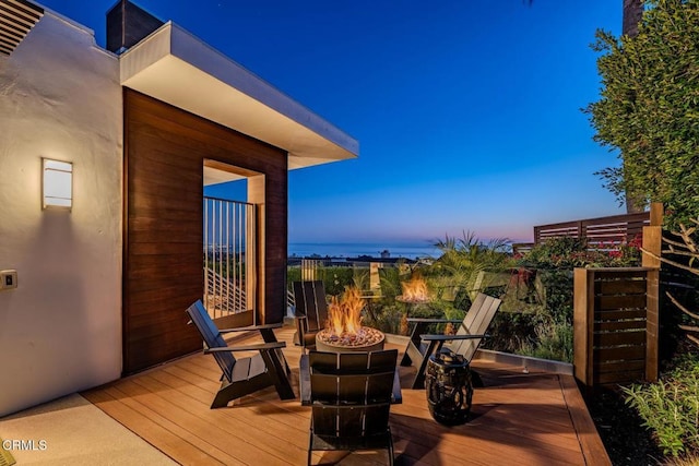 deck at dusk featuring an outdoor fire pit