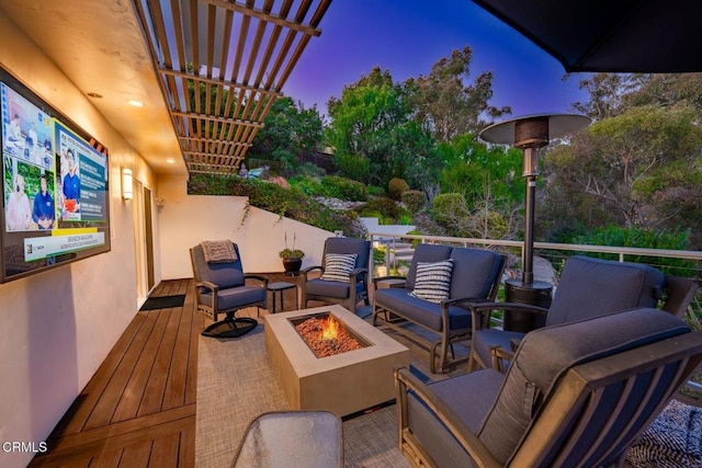 view of patio with an outdoor living space with a fire pit
