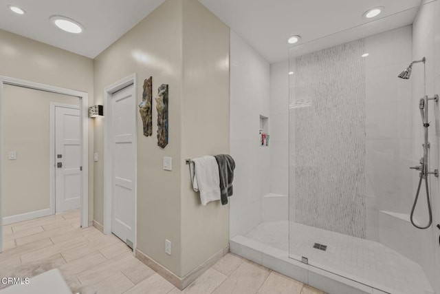 full bathroom featuring baseboards, wood tiled floor, a tile shower, and recessed lighting