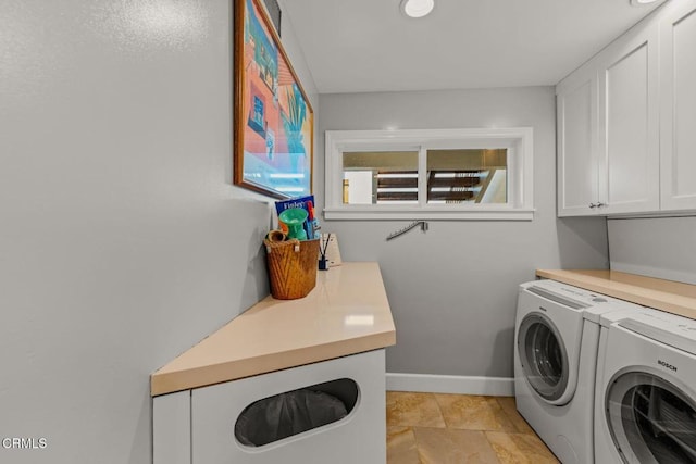 laundry room with washing machine and clothes dryer, cabinet space, and baseboards