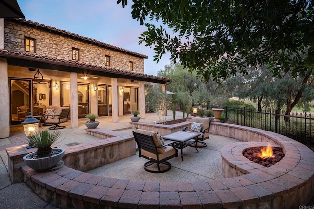 patio terrace at dusk with a fire pit and fence