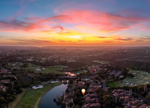 aerial view at dusk featuring a water view