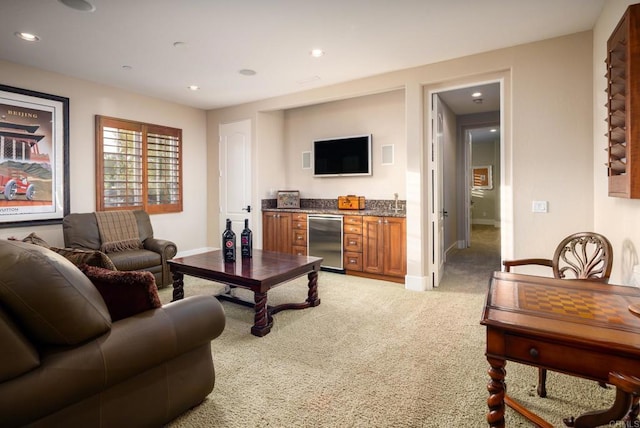 living area featuring a bar, recessed lighting, light colored carpet, and baseboards