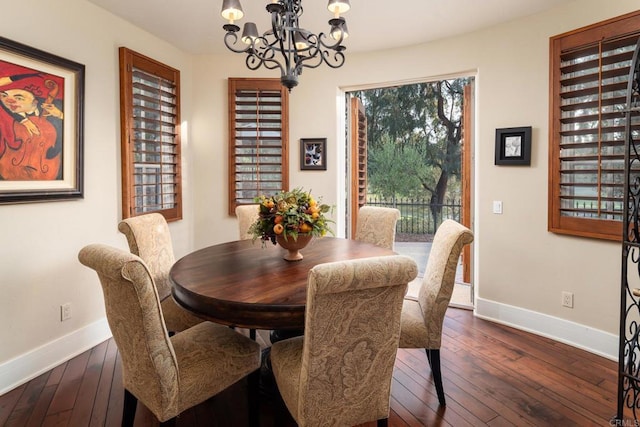 dining space with baseboards, dark wood-type flooring, and a chandelier