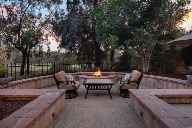 view of patio featuring an outdoor fire pit and fence