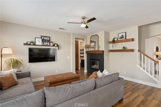 living room with visible vents, baseboards, ceiling fan, stairs, and wood finished floors