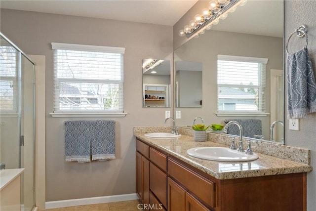 bathroom featuring a sink, an enclosed shower, double vanity, and tile patterned floors