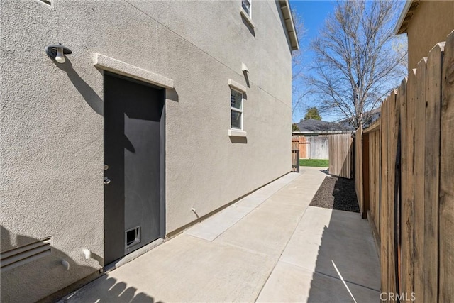 view of home's exterior featuring a patio area, stucco siding, and fence