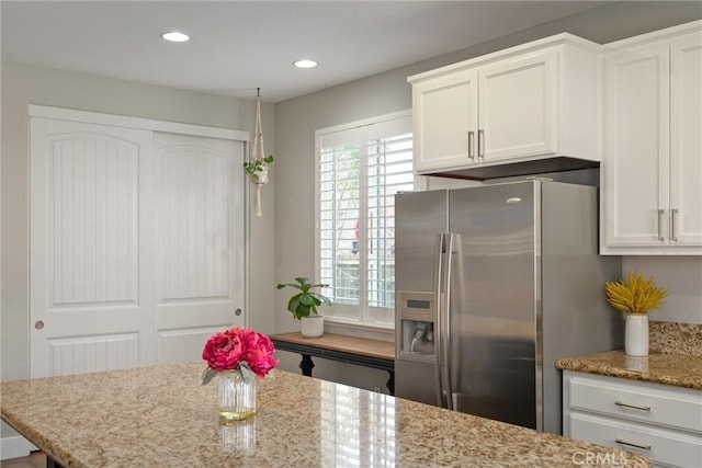 kitchen with white cabinetry, light stone counters, stainless steel fridge with ice dispenser, and recessed lighting