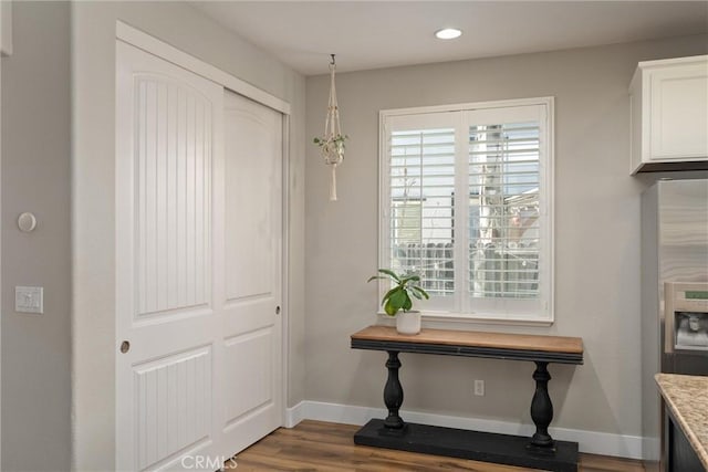 interior space with recessed lighting, refrigerator with ice dispenser, wood finished floors, and baseboards