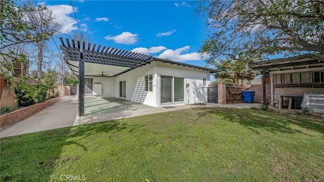 rear view of house with a patio, fence, a lawn, and a gate