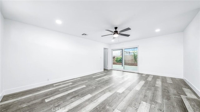 empty room featuring wood finished floors, baseboards, visible vents, recessed lighting, and ceiling fan