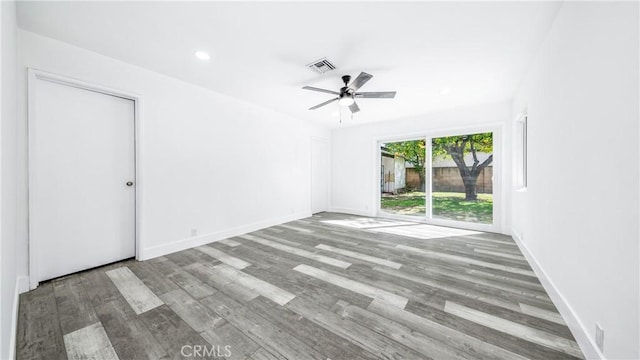 spare room with visible vents, a ceiling fan, wood finished floors, recessed lighting, and baseboards