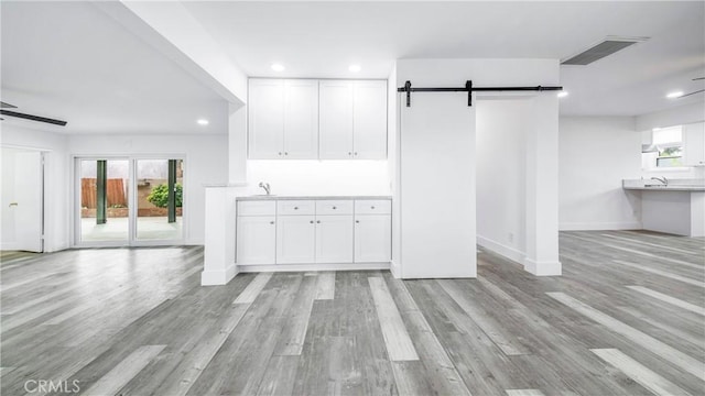 unfurnished living room with a wealth of natural light, visible vents, light wood-style flooring, and recessed lighting