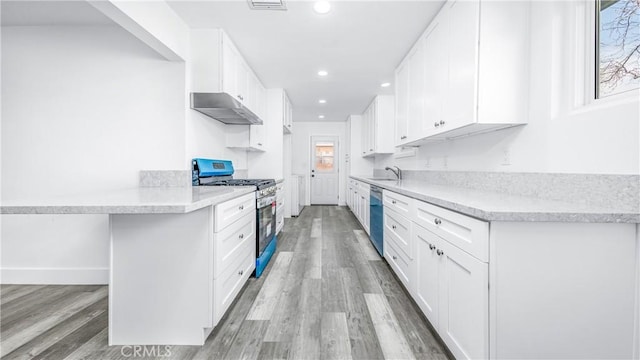 kitchen featuring under cabinet range hood, dishwasher, light wood-style flooring, white cabinets, and gas stove