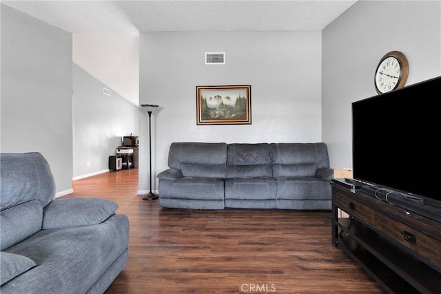 living area featuring visible vents, baseboards, a textured ceiling, and wood finished floors