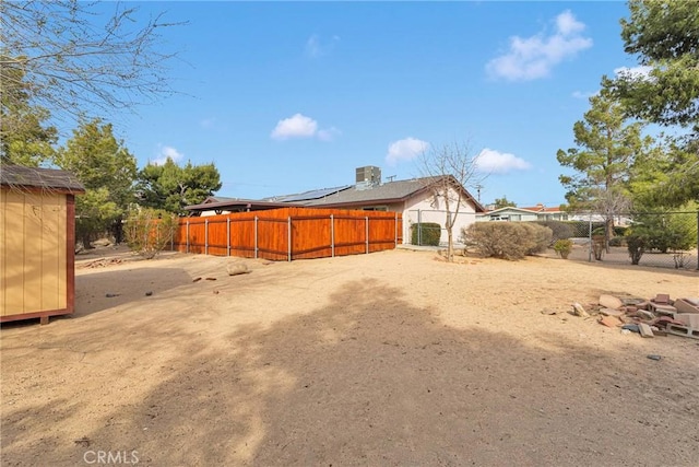 back of property with a shed, fence private yard, and an outdoor structure