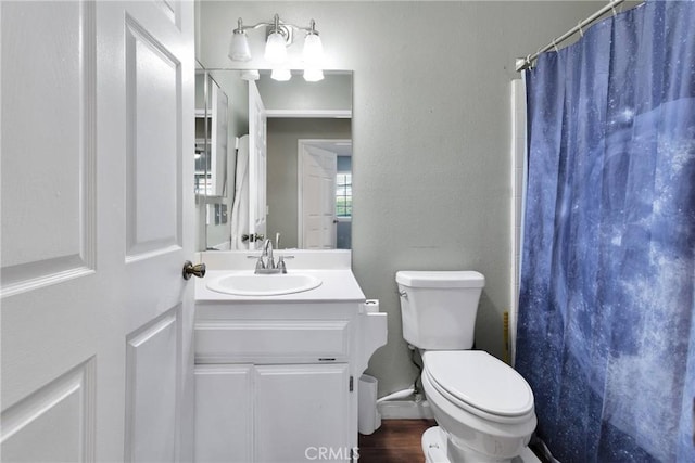 bathroom with curtained shower, toilet, vanity, and wood finished floors