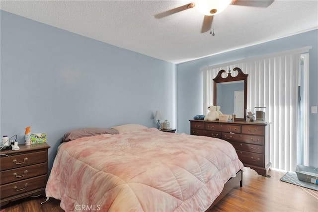 bedroom featuring a textured ceiling, wood finished floors, and a ceiling fan