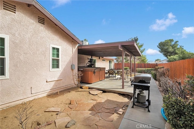 view of patio / terrace featuring a grill, a hot tub, and a fenced backyard