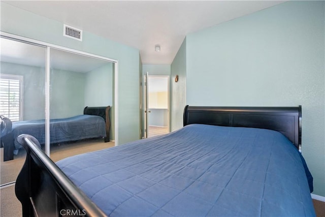 bedroom featuring carpet flooring, visible vents, and a closet