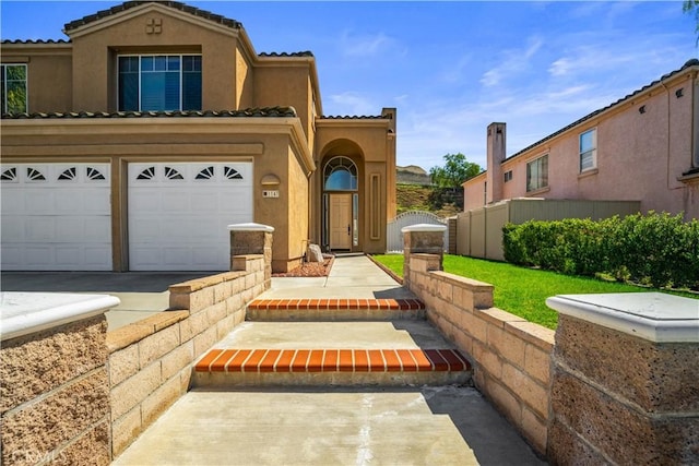 view of front facade with a gate, fence, stucco siding, a garage, and a tile roof