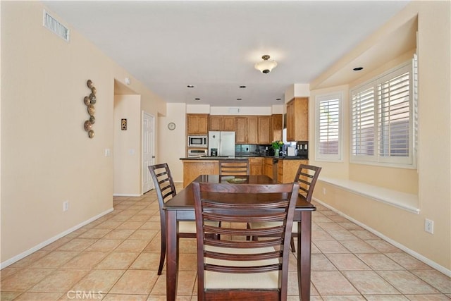 dining room with light tile patterned floors, visible vents, and baseboards