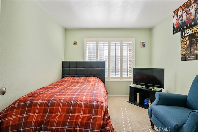 bedroom with baseboards and carpet