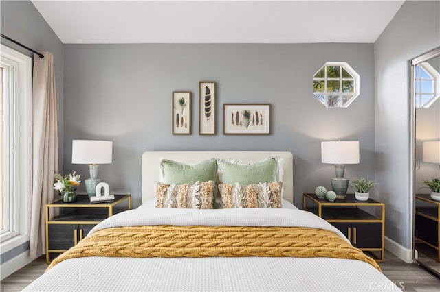 bedroom featuring baseboards and wood finished floors