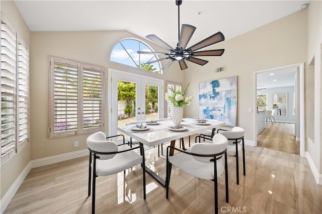 dining space with french doors, high vaulted ceiling, visible vents, and light wood finished floors