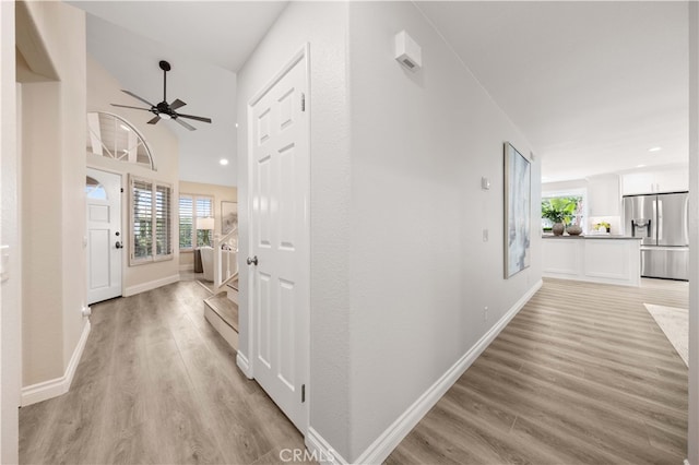 corridor with recessed lighting, light wood-style floors, and baseboards