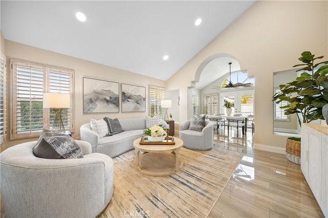 living area featuring baseboards, ceiling fan, recessed lighting, arched walkways, and high vaulted ceiling