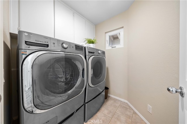 laundry room featuring light tile patterned floors, cabinet space, independent washer and dryer, and baseboards