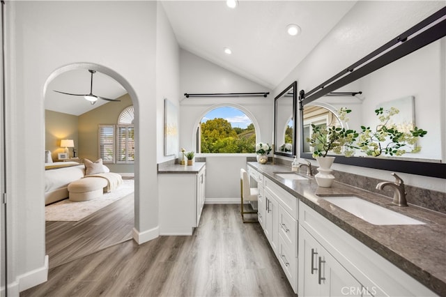 bathroom with double vanity, wood finished floors, ensuite bath, and a sink