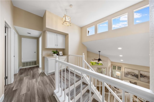 hallway featuring visible vents, an upstairs landing, wood finished floors, recessed lighting, and baseboards