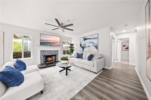 living area with baseboards, recessed lighting, a tile fireplace, wood finished floors, and a ceiling fan