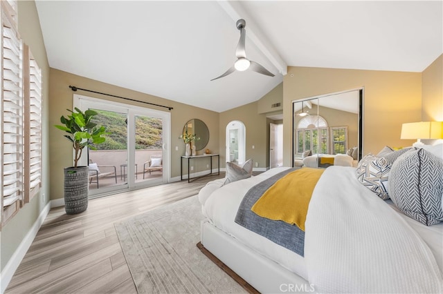 bedroom featuring multiple windows, wood finished floors, lofted ceiling with beams, and access to outside