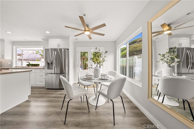 dining room with plenty of natural light, ceiling fan, and wood finished floors